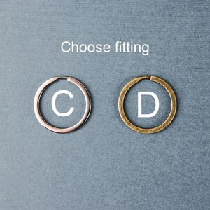May include: Two metal key rings, one silver and one gold, with the letters "C" and "D" printed on them. Choose fitting.