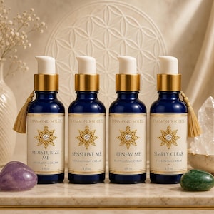 Puede incluir: Cuatro botellas de vidrio azul oscuro con detalles dorados y bombas blancas, etiquetadas como "Diamond Soleil". Cada botella tiene una etiqueta diferente: "Moisturize Me", "Sensitive Me", "Renew Me" y "Simply Clear". Las botellas son de 30 ml cada una.
