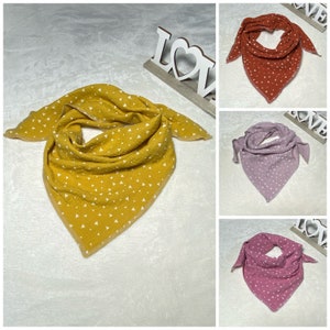 Könnte beinhalten: Drei dreieckige Stoffscarves mit weißen Dreiecksmustern. Die Schals sind in Senfgelb, Rostorange und Rosa.