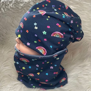 Könnte beinhalten: Ein schwarzes Mützen- und Halstuch-Set mit einem Regenbogen- und Blumenmuster.