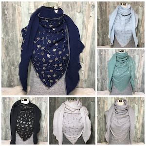 Könnte beinhalten: Sechs verschiedene Farbvarianten eines dreieckigen Schals mit einem goldenen Blattmotiv. Der Schal ist aus einem weichen, strukturierten Stoff gefertigt und hat ein einzigartiges Design.