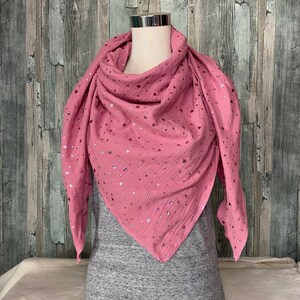 May include: A pink triangular scarf with a glittery pattern of small hearts. The scarf is made of a soft, gauzy fabric.