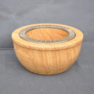 May include: A wooden bowl with a brass ring around the top. The ring is decorated with a series of small metal pieces.