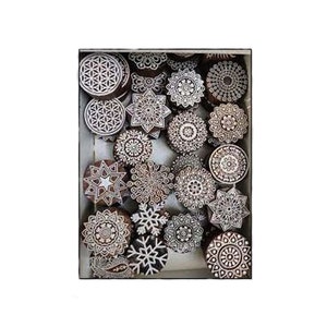 May include: A collection of intricately carved wooden printing blocks with various geometric and floral designs. The blocks are in a rectangular box, showcasing a variety of shapes and patterns, including circles, stars, and snowflake-like motifs. The wood has a natural, warm tone.