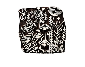 May include: A black and white floral block print featuring stylized flowers, leaves, and a butterfly. The design is carved into a rectangular wooden block, perfect for textile printing or crafting projects. The block has a rustic, handmade appearance.