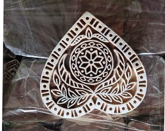 Op de afbeelding: Een houten hartvormige blokstempel met een gedetailleerd bloemenontwerp. Het ontwerp heeft een centraal mandala met bladeren en een rand van herhalende patronen.