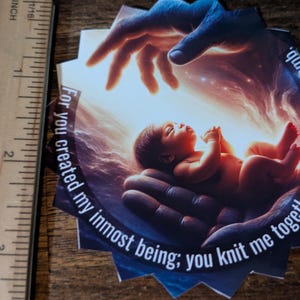 Puede incluir: Una impresión en forma de estrella que representa a un bebé en una mano, con otra mano encima. La imagen tiene un fondo celestial e incluye el texto: "Porque tú creaste mi ser más íntimo; me tejiste junto en el vientre de mi madre."