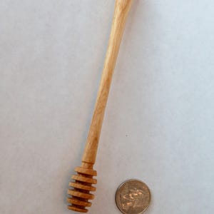 Pu&ograve; includere: Un mestolo di legno per il miele con un design a spirale all'estremit&agrave;. Il mestolo &egrave; lungo circa 18 cm ed &egrave; fatto di legno marrone chiaro.