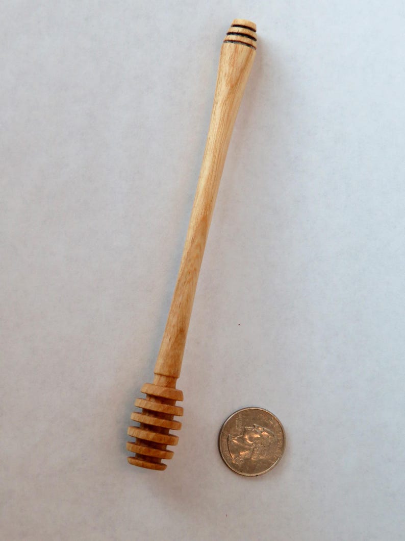 Pu&ograve; includere: Un mestolo di legno per il miele con un design a spirale all'estremit&agrave;. Il mestolo &egrave; lungo circa 18 cm ed &egrave; fatto di legno marrone chiaro.