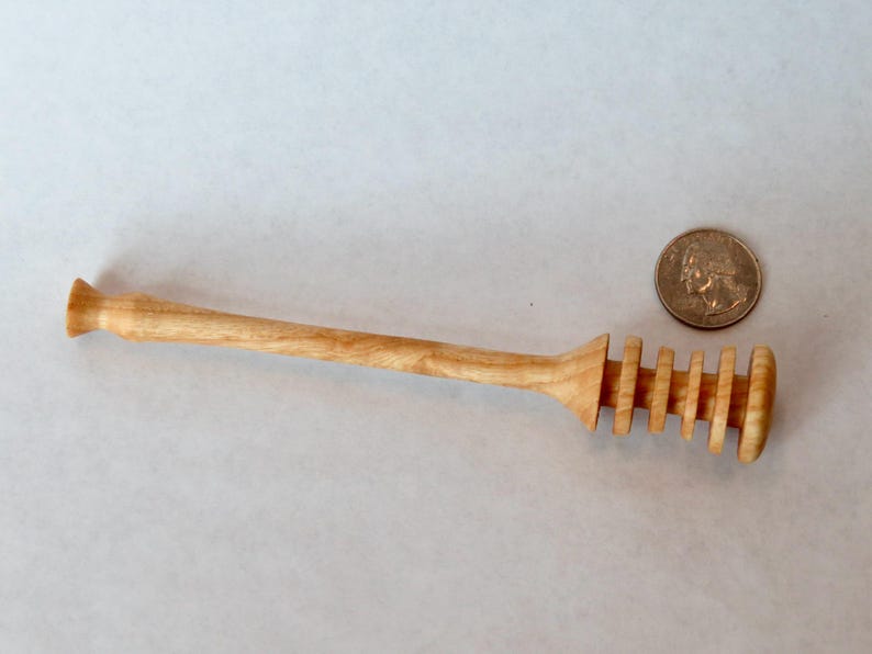 Pu&ograve; includere: Un mestolo per miele in legno con finitura naturale e un design a spirale all'estremit&agrave;. Il mestolo &egrave; lungo circa 18 cm.