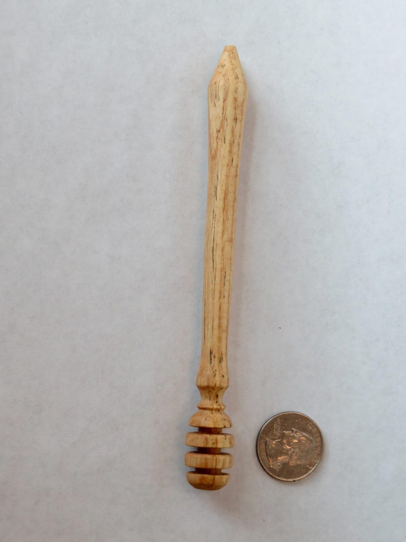 Pu&ograve; includere: Un mestolo per miele in legno con un manico arrotondato e un mestolo a forma di favo di miele all'estremit&agrave;. Il mestolo &egrave; circa delle dimensioni di una moneta da 20 centesimi di euro.