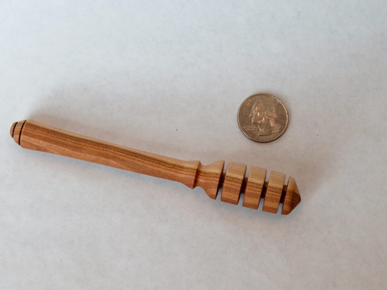 Pu&ograve; includere: Un mestolo per miele in legno con finitura in legno naturale e un design a nido d'ape. Il mestolo &egrave; lungo circa 15 cm.