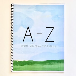 May include: A spiral bound notebook with a blue and green watercolor background. The cover features the text "A-Z Write and Draw the Psalms".