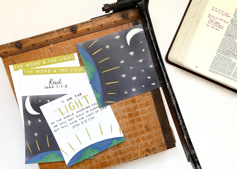 May include: A set of printable cards with a blue and green earth illustration, a crescent moon, and stars. The cards feature the text "The Word & The Light", "Read John 1:1-5", "I am the Light of the world. Whoever follows me will not walk in darkness, but will have the light of life. John 8:12 ESV".