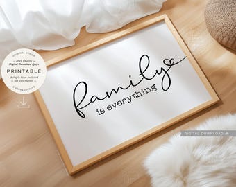May include: A framed white print with the words "Family is everything" in black script. The print is in a light wood frame and sits on a wooden surface. A fluffy white rug and a woven basket are also visible.