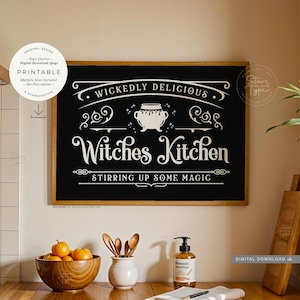 May include: A framed black sign with the text "Witches Kitchen" in white, with the words "Wickedly Delicious" above and "Stirring Up Some Magic" below. The sign is surrounded by a wooden frame. A bowl of oranges and a bottle of soap are in the foreground.