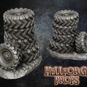 Op de afbeelding: Een stapel van vijf grijze rubberen banden met een profiel. De banden zijn op een grijze, rotsachtige ondergrond gestapeld. De banden zijn een rekwisiet voor tabletop-spellen.