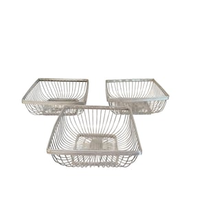 May include: A set of three square wire baskets featuring a silver-toned metallic finish. Each basket is constructed with thin, evenly spaced vertical wire bars forming the sides and a grid-like base, creating an open, airy structure.