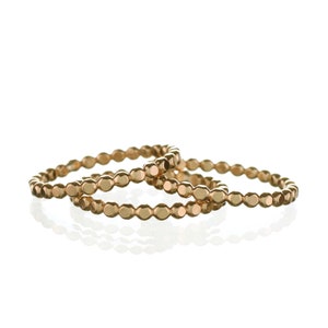 May include: Three gold rings with a beaded design. The rings are stacked on top of each other.