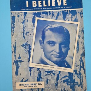 May include: Vintage sheet music titled "I Believe" with a blue and white design. The cover features a portrait of Frankie Laine and text indicating the song's composers and publisher, Cromwell Music, Inc. Price 40c.