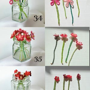 May include: Three sets of handcrafted beaded flower stems labeled 34, 35, and 36. Set 34 features pink beaded flowers, set 35 displays red flowers with layered petals, and set 36 shows dark red flowers, all with green beaded stems in glass jars.