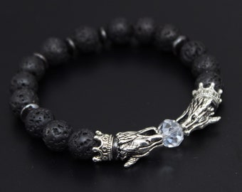 May include: Black lava rock beaded bracelet with a silver dragon charm and a clear crystal bead.