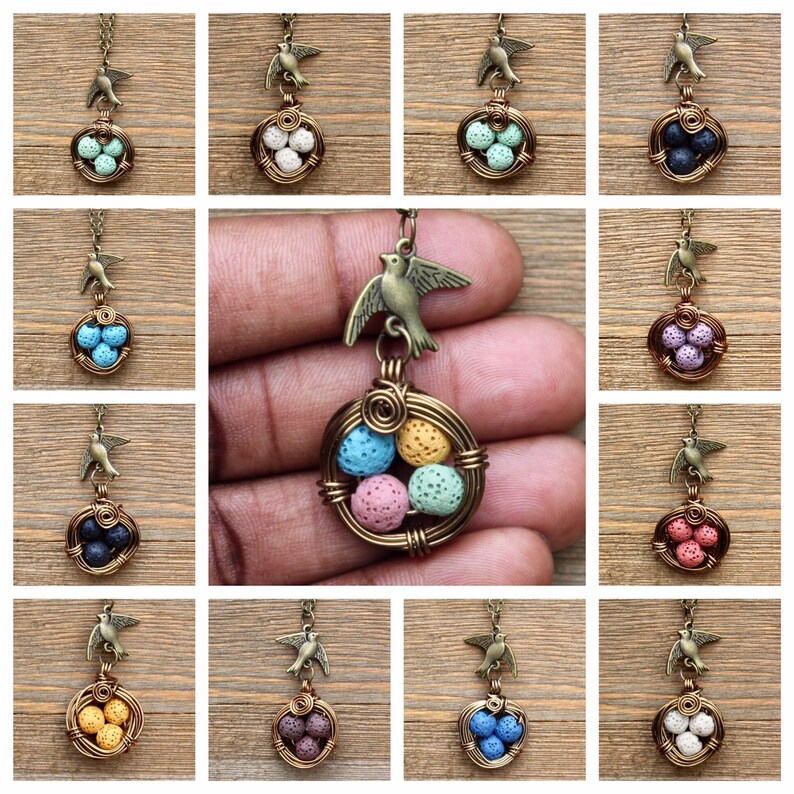 May include: A necklace with a bird charm and a wire nest with five lava rock eggs in various colors. The colors of the eggs are pink, blue, yellow, green, and white.