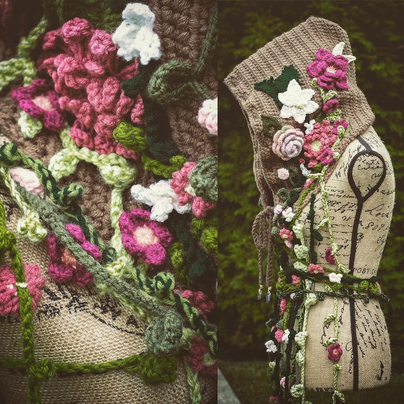 May include: A crocheted hooded scarf with floral embellishments in shades of pink, white, and green. The scarf is draped over a mannequin with a handwritten note on the torso.