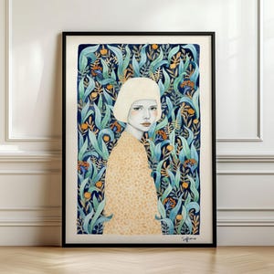 May include: A framed art print featuring a portrait of a person with a short blonde bob haircut wearing a beige patterned top. The background consists of a dense arrangement of blue-green leaves and small orange berries in a dark blue setting.