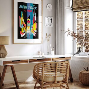 Pu&ograve; includere: Un ufficio domestico con una scrivania bianca, una sedia in vimini e un poster incorniciato che recita "NEW YORK FLY TWA". Il poster presenta un design colorato e astratto dello skyline di New York.