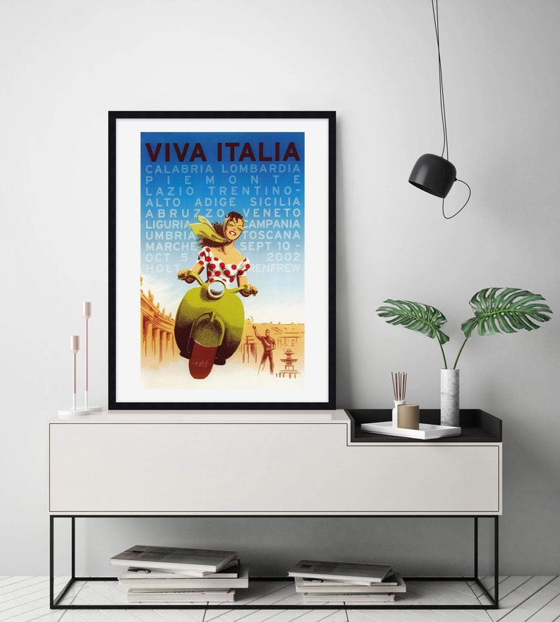K&ouml;nnte beinhalten: Ein Vintage-Reiseposter, das eine Tour durch Italien bewirbt. Das Poster zeigt eine Frau, die auf einem gr&uuml;nen Roller vor einem Geb&auml;ude mit blauem Himmel im Hintergrund f&auml;hrt. Der Text auf dem Poster lautet "Viva Italia" und listet verschiedene Regionen Italiens auf.