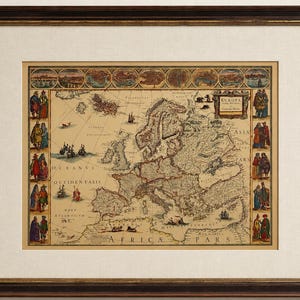 May include: A framed antique-style map of Europe featuring a central cartographic illustration, decorative borders with historical figures, and a top row of city vignettes. The map includes the text "EUROPA" and "AFRICA PARS" in a dark wood frame.