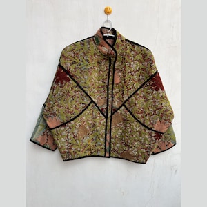 May include: A green, brown, and red patterned jacket with black trim. The jacket has a zipper closure and a high collar.