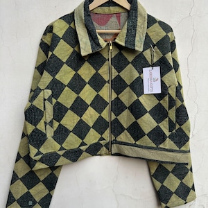 May include: A cropped jacket featuring a black and olive green diamond pattern, a fold-over collar, and a gold-tone front zipper. A white tag attached to the garment displays the text Laressa Gifts.