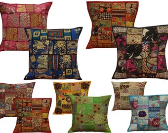 Puede incluir: Una colección de cojines decorativos con diseños de patchwork. Los cojines presentan una variedad de colores, incluyendo rojo, azul, verde y dorado. Cada cojín tiene un patrón único, con cuadrados y rectángulos de tela cosidos.