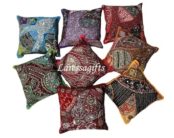 May include: Nine colorful square throw pillows with intricate embroidery and embellishments. The pillows are made of various fabrics and feature a mix of sequins, beads, and other decorative elements.
