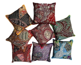 May include: Eight decorative throw pillows with colorful embroidered patterns and sequins. The pillows are made of fabric and have a variety of colors, including red, green, blue, purple, and gold.
