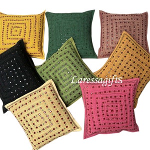 Puede incluir: Surtido de ocho almohadas cuadradas con diseños bordados y detalles de espejo. Las almohadas son de varios colores, incluyendo negro, verde, amarillo, naranja y rosa.