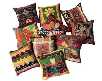 May include: A set of nine colorful, patterned throw pillows with floral embroidery. The pillows are made of a variety of fabrics and feature different colors and designs.