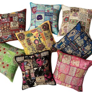 May include: Assortment of eight colorful throw pillows with embroidered patchwork designs. The pillows are made of various fabrics and feature different colors, including red, green, blue, yellow, and pink.