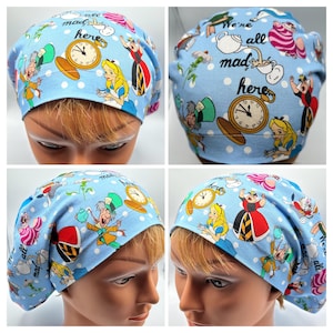 May include: Blue surgical scrub hat with a white polka dot pattern and a colorful Alice in Wonderland print featuring characters like the Mad Hatter, the Queen of Hearts, and Alice. The hat has the text "We're all mad here" printed on it.