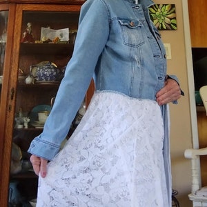 May include: A light blue denim jacket with a white lace skirt. The jacket has a distressed look and the skirt has a floral pattern.