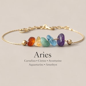 Könnte beinhalten: Ein goldfarbenes Kettenarmband mit fünf polierten, unregelmäßigen Edelsteinperlen in Orange, Gelb, Grün, Hellblau und Violett. Der Text Aries, Carnelian, Citrine, Aventurine, Aquamarine, Amethyst ist unter dem Armband aufgedruckt.