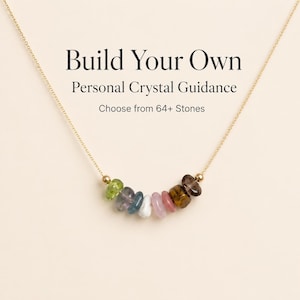 May include: A gold-colored necklace with a pendant of colorful gemstones. The necklace features a variety of stones in shades of green, blue, pink, and brown. Text on the image reads "Build Your Own Personal Crystal Guidance. Choose from 64+ Stones."