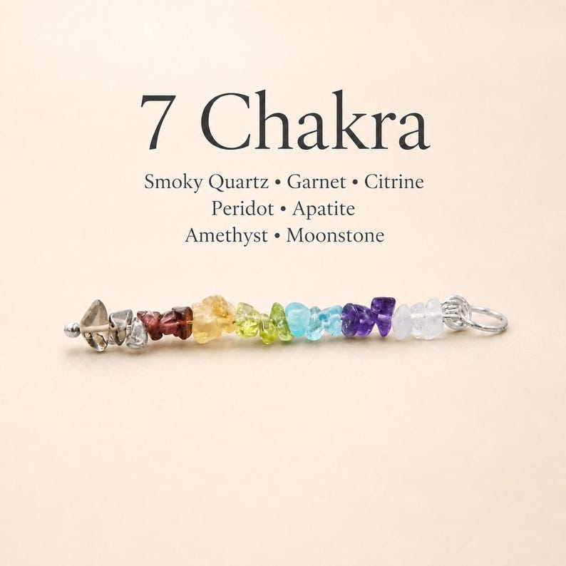 Pu&ograve; includere: Un ciondolo con sette pietre preziose: quarzo fum&eacute;, granato, citrino, peridoto, apatite, ametista e pietra di luna. Le pietre sono disposte in sequenza arcobaleno. Il ciondolo ha un anello in metallo color argento. Il testo "7 Chakra" &egrave; visualizzato sopra.