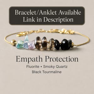 May include: A gold-toned chain bracelet featuring a row of raw, tumbled gemstone beads including green and blue fluorite, light purple amethyst, brown smoky quartz, and black tourmaline. Text reads: Bracelet/Ankle Available Link in Description, Empath Protection, Fluorite, Smoky Quartz, Black Tourmaline.