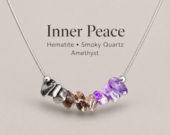 May include: A silver-toned snake chain necklace featuring a row of tumbled gemstone beads in shades of metallic gray, brown, and purple. The text Inner Peace, Hematite, Smoky Quartz, and Amethyst is printed above the stones.