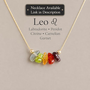 May include: A gold chain necklace featuring five raw gemstone chips in shades of grey, green, yellow, orange, and dark red, flanked by two gold beads. Text reads: Necklace Available Link in Description, Leo, Labradorite, Peridot, Citrine, Carnelian, Garnet.