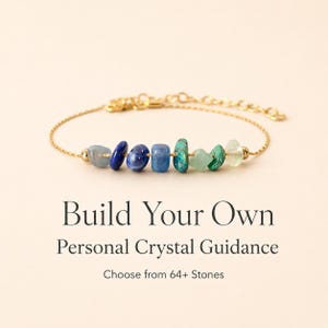 May include: A gold-colored chain bracelet featuring a series of colorful gemstones in shades of blue and green. The bracelet has a delicate design and is displayed against a soft, neutral background. Text on the image reads: "Build Your Own Personal Crystal Guidance."