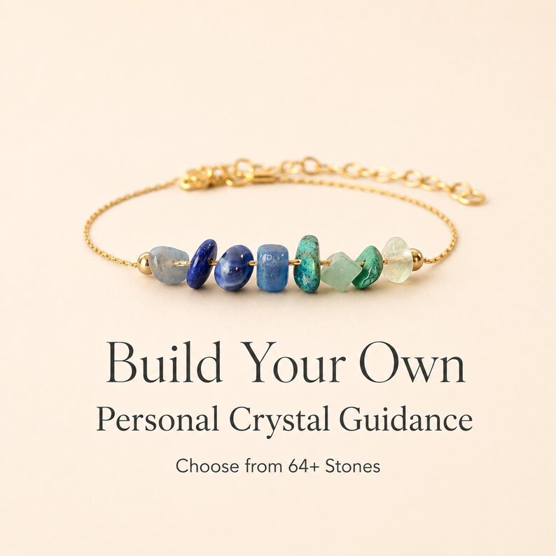 May include: A gold-colored chain bracelet featuring a series of colorful gemstones in shades of blue and green. The bracelet has a delicate design and is displayed against a soft, neutral background. Text on the image reads: "Build Your Own Personal Crystal Guidance."